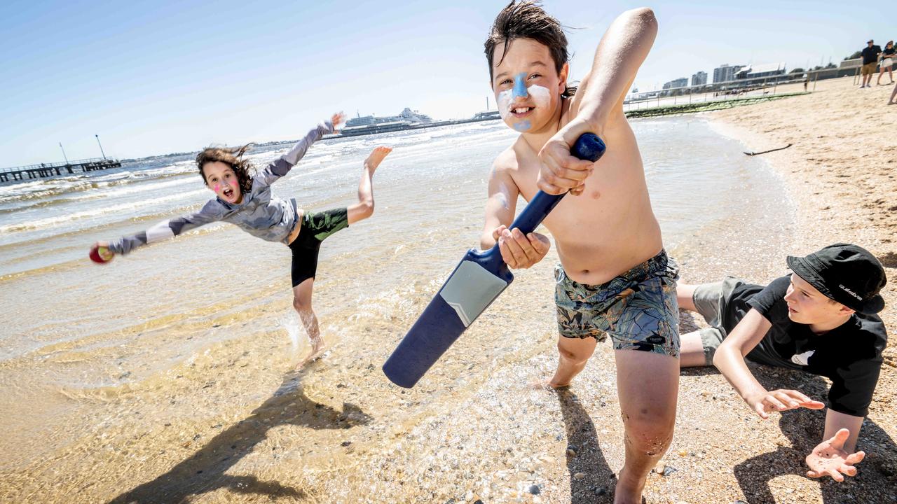 Ella, 8, Harry, 11, and Alex, 13, get some beach cricket in at Port Melbourne Beach as the temperature spikes. Picture: Tony Gough