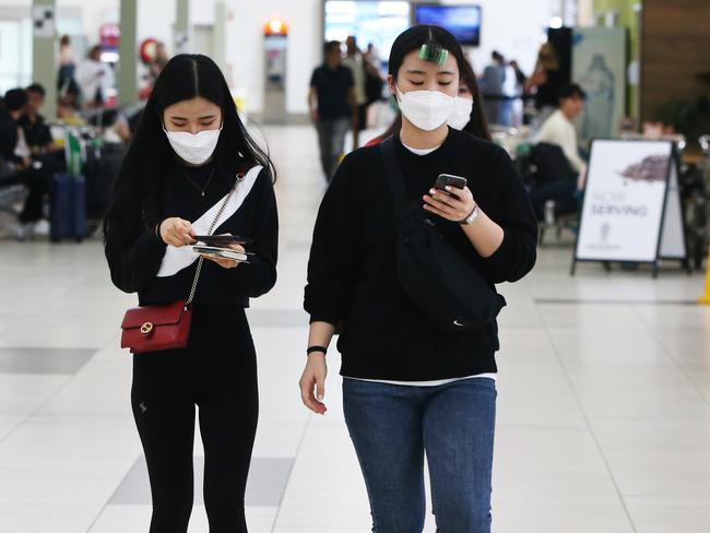 Tourists wearing masks at Gold Coast Airport as the Coronavirus epidemic causes havoc with peoples travel plans.  . Picture Glenn Hampson