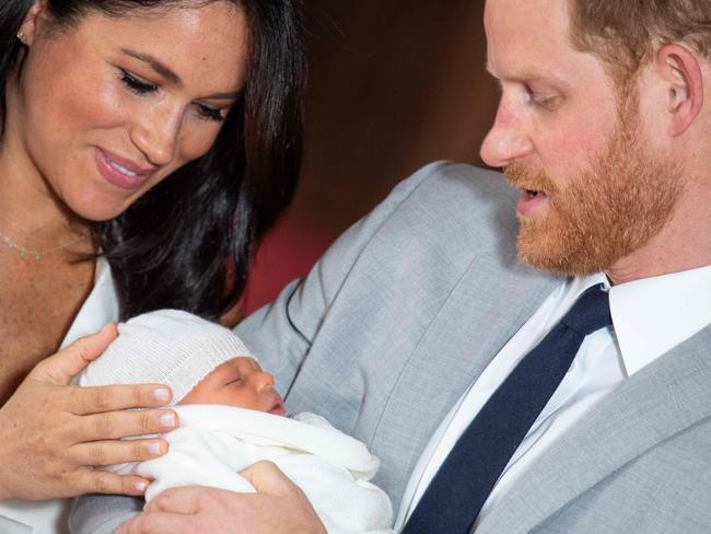 TOPSHOT - Britain's Prince Harry, Duke of Sussex (R), and his wife Meghan, Duchess of Sussex, pose for a photo with their newborn baby son, Archie Harrison Mountbatten-Windsor, in St George's Hall at Windsor Castle in Windsor, west of London on May 8, 2019. (Photo by Dominic Lipinski / POOL / AFP)