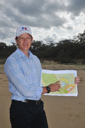 Sekisui erected cranes in 2015 to show building height of the tallest proposed building plus the position of the front building. Sekisui House Senior Development Manager, Evan Aldridge on Yaroomba beach with cranes behind him. 