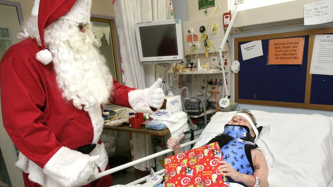 Rouse Hill Renegades’ Santa hands over a present to Kye Wilson at the ward.