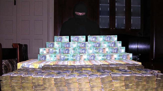 Shayne Hatfield poses with a huge pile of cash in a 2005 photo. It was found when police from Operation Mocha raided Hatfield’s house.