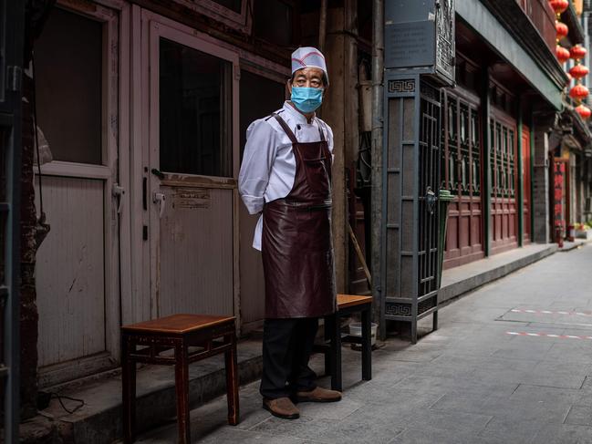 A cook takes a break outside his restaurant in Beijing. Picture: AFP