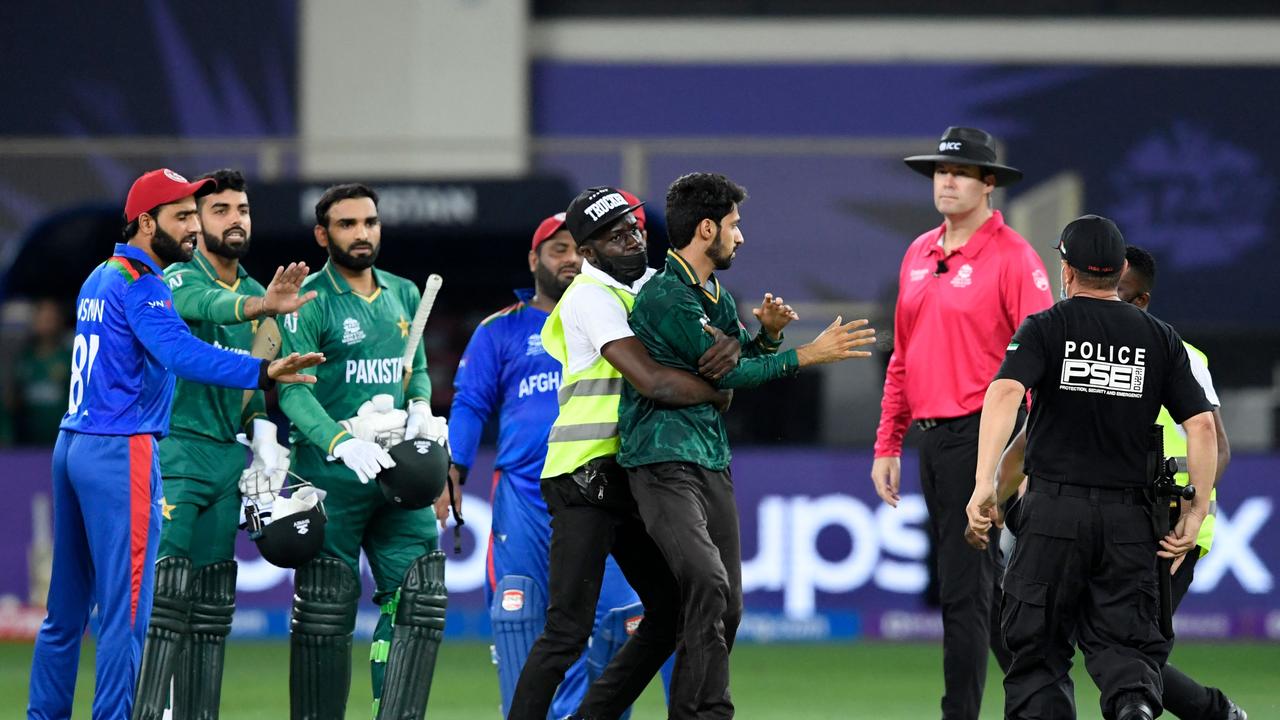 Security personnel detain a spectator (C) who entered the ground.