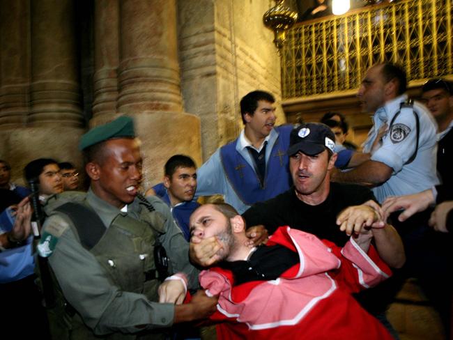 Israeli policemen intervene during a fight between Armenian clergy and Greek Orthodox monks at the church of the Holy Sepulcher in Jerusalem. Picture: AP