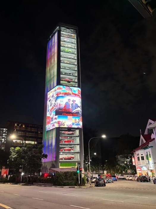 Birtles and the Bean: Team Bean Matthew Benns and Daily Telegraph cartoonist Warren Brown view the car vending machine at Singapore, which had the 100-year-old car inside.