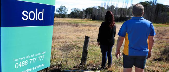 Rouse Hill residents Kelly Zammit and Neil Poullos in front of the proposed bus depot site on Mile End Rd in Rouse Hill. Pic: AAP Image / Angelo Velardo