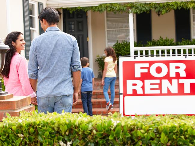 Hispanic family outside home for rent holding hands looking at each other happy