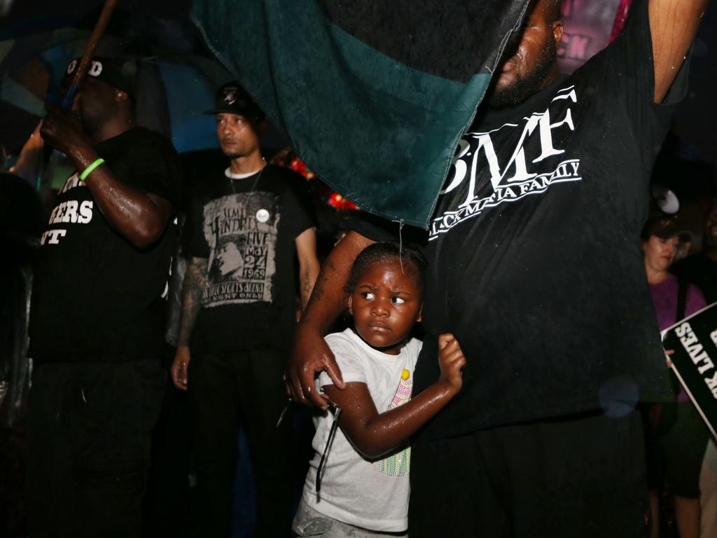 A young African American girl clings to her father during a Black Lives Matter protest in Memphis. Pictures: Gary Ramage