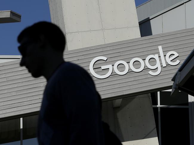 FILE - In this Nov. 12, 2015, file photo, a man walks past a building on the Google campus in Mountain View, Calif. Google said Wednesday, May 11, 2016, that it will ban ads from payday lenders, calling the industry “deceptive” and “harmful.” Google said it will no longer allow ads for loans due within 60 days and will also ban ads for loans where the interest rate is 36 percent or higher. The ban is effective July 13. (AP Photo/Jeff Chiu, File)