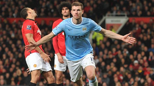 (Files) In this file picture taken on March 25, 2014, Manchester City's Bosnian forward Edin Dzeko celebrates after scoring the second goal during the English Premier League football match against Manchester United at Old Trafford in Manchester. Manchester City striker Edin Dzeko on Wednesday, August 20, 2014, signed a new four-year contract which will keep him at the Premier League champions until at least 2018. The Bosnian international's current deal had only 10 months to run and manager Manuel Pellegrini's determination to keep the striker was fully justified by his performance as City beat Newcastle 2-0 on Sunday. AFP PHOTO/PAUL ELLIS RESTRICTED TO EDITORIAL USE. No use with unauthorized audio, video, data, fixture lists, club/league logos or “live” services. Online in-match use limited to 45 images, no video emulation. No use in betting, games or single club/league/player publications.