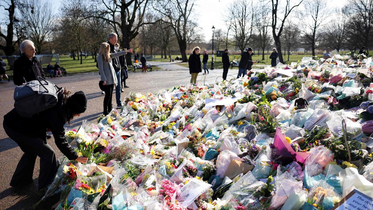 A well-wisher places a floral tribute in honour of Sarah Everard. Picture: Tolga Akmen / AFP