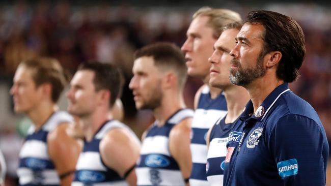 Cats coach Chris Scott and Geelong players stand for the national anthem during finals.