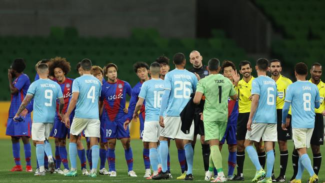 Melbourne City and Ventforet Kofu players, as well as match officials, shake hands at AAMI Park on Wednesday night. Picture: Robert Cianflone/Getty Images