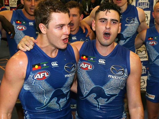 Debutants Tom Murphy (left) and Paul Ahern of the Kangaroos sing the song in the rooms after the Round 11 AFL match between the North Melbourne Kangaroos and the Brisbane Lions at Etihad Stadium in Melbourne, Sunday, June 3, 2018. (AAP Image/Hamish Blair) NO ARCHIVING, EDITORIAL USE ONLY