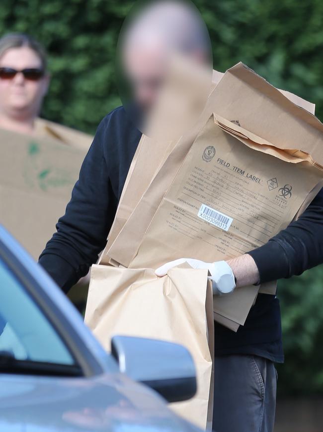 A police officer takes away evidence. Picture: John Grainger 