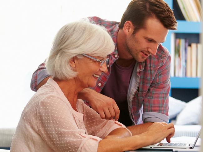 Son Giving Senior Parent Financial Advice In Home Office