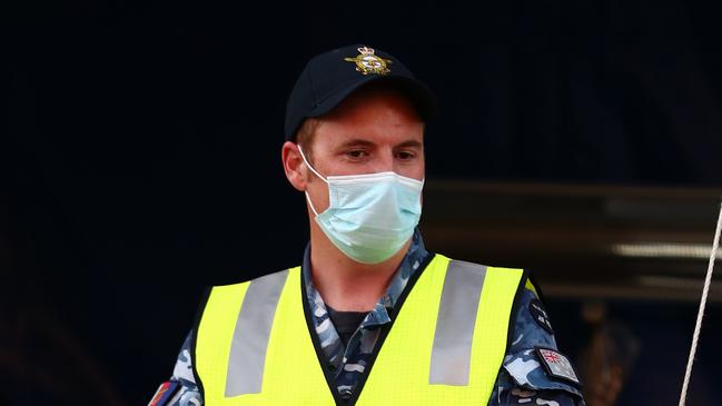 An Australian Defence Force member stops cars in Griffith street Coolangatta at the Queensland border. (Photo by Chris Hyde/Getty Images).