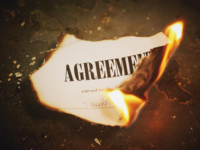 A printed legal document titled Agreement has been set alight and is burning to ash; inheritance, will, estate planning generic