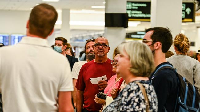 Commuters with and without face masks at the security check at the Miami International Airport in Miami. Picture: AFP.