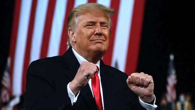 Donald Trump holds up his fists at the end of a rally to support Republican Senate candidates at Valdosta Regional Airport in Valdosta, Georgia.