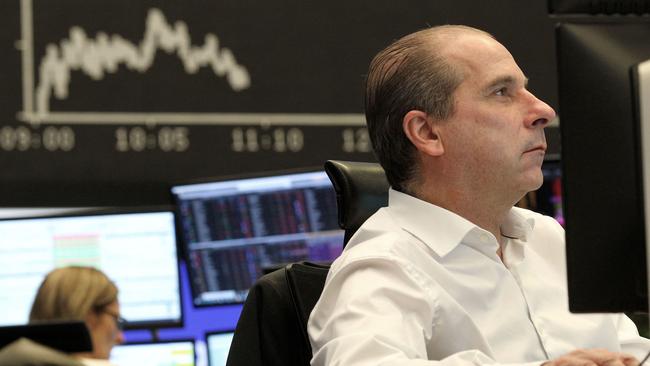 A trader works in front of a board displaying Germany’s share index DAX at the stock exchange in Frankfurt am Main on Thursday. Picture: AFP