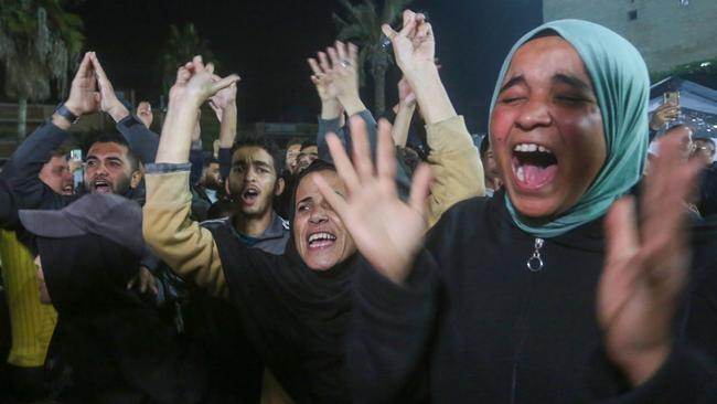 Palestinians celebrate the announcement of a ceasefire between Israel and Hamas.