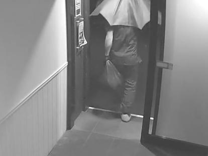 The man can be seen leaving the hotel under the cover of an umbrella. Picture: NSW Police