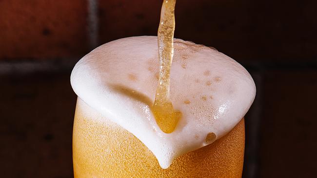 Pouring beer into glass close up