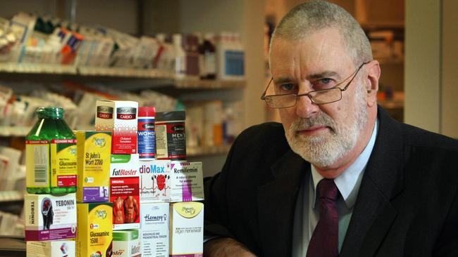 Professor Ken Harvey with a selection of complementary medicines on offer at a pharmacy. 