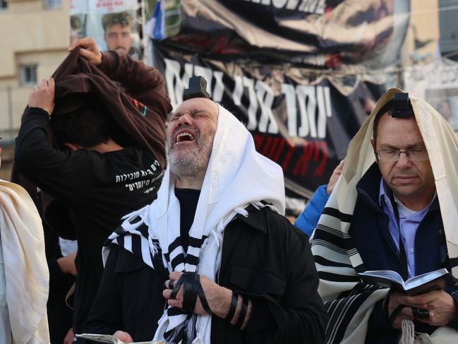 Men wearing the Tallit prayer shawl pray and react as people gather in Tel Aviv to mark the 100th day after the attack by Hams fighters on Israel that was followed by a war between Israel and the Palestinian Hamas movement. Picture: Gil Cohen-Magen/AFP