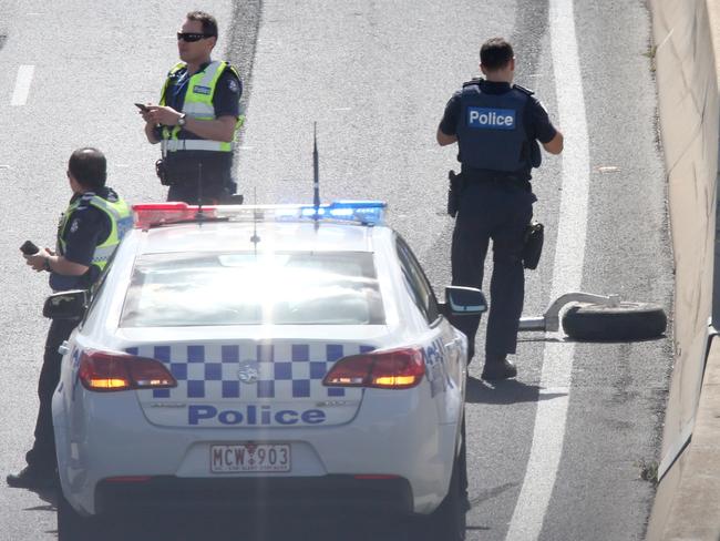 Police photograph one of the aircraft’s wheels lying on the freeway. Picture: Mark Wilson