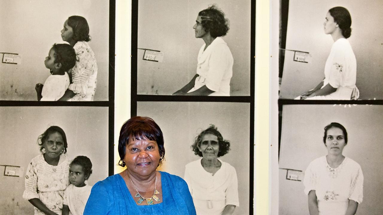 Aunty Flo Watson standing in front of portraits at the Transforming Tindale exhibition, State Library of Queensland, Brisbane, 2012. Photo: Mick Richards