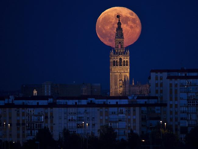 The moon rises over the tower of Seville's Cathedral in Spain. AP Photo/Miguel Angel Morenatti