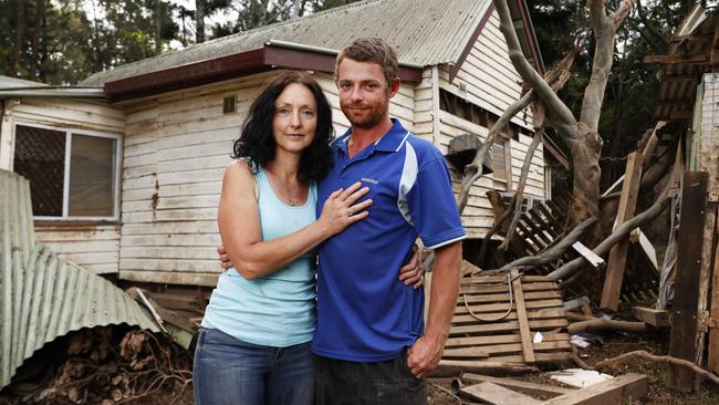 Mitch Moore and his wife Heather Lickiss outside their home on Lake St in North Lismore that was washed 50 metres into their neighbour’s backyard by the flooding Wilsons River. The couple escaped into their roof before cutting a hole in the corrugated roof to be rescued by boat. Picture: Jonathan Ng