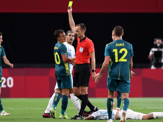 SAPPORO, JAPAN - JULY 22: Denis Genreau #10 of Team Australia is shown a yellow card by Match Referee, Srdan Jovanovic during the Men's First Round Group C match between Argentina and Australia during the Tokyo 2020 Olympic Games at Sapporo Dome on July 22, 2021 in Sapporo, Hokkaido, Japan. (Photo by Masashi Hara/Getty Images)