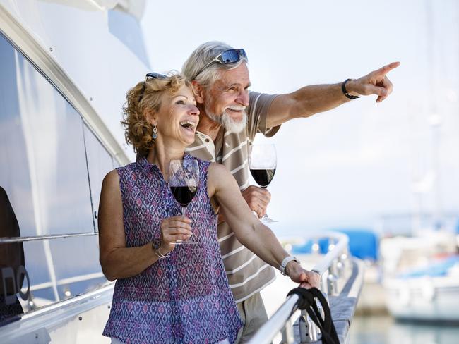 Happy senior couple enjoying wine on yacht. seniors and retirees travel, holidays, generic