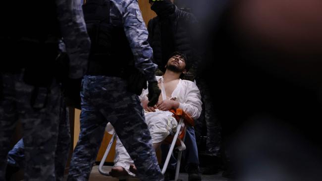 A man suspected of taking part in the attack of a concert hall is escorted by Russian law enforcement officers prior to his pre-trial detention hearing. Picture: AFP