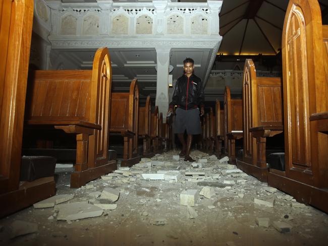 A man walks inside a cathedral where debris has fallen after an earthquake struck Bali. Picture: AP.