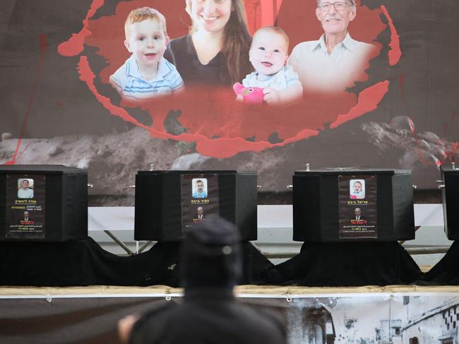 The coffins of the four Israeli hostages sit on stage during the handing them over to the Red Cross in Khan Yunis in the southern Gaza on February 20, 2025. Hamas handed over on February 20 coffins believed to contain the bodies of four Israeli hostages, including those of the Bibas family who became symbols of the ordeal that has gripped Israel since the Gaza war began. (Photo by Eyad BABA / AFP)