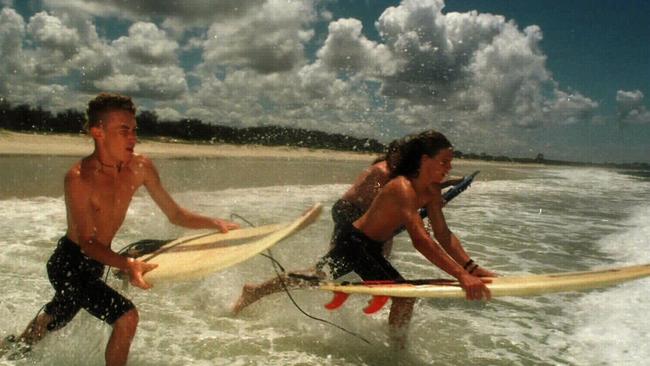 November 21, 1997: Schoolies go surfing at Fingal Beach, Shawn Brettle, 17 (L) and Damian Freeleagus, 17 and Nathan Tronson (behind) hit the waves Picture: Paul Riley