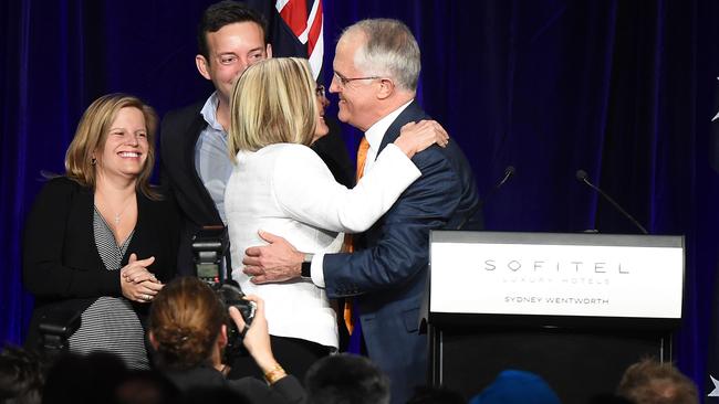 Australian Prime Minister Malcolm Turnbull kisses wife Lucy with daughter Daisy and son Alex nearby at the Liberal Party election night event.