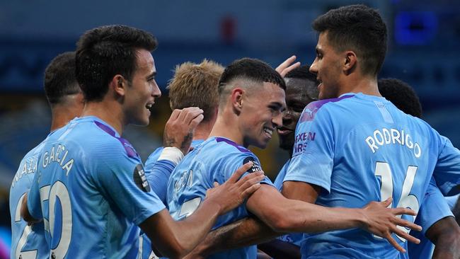 Manchester City players celebrate after Phil Foden (C) scored their third goal during the English Premier League football match between Manchester City and Liverpool at the Etihad Stadium in Manchester, north west England, on July 2, 2020. (Photo by Dave Thompson / POOL / AFP) / RESTRICTED TO EDITORIAL USE. No use with unauthorized audio, video, data, fixture lists, club/league logos or 'live' services. Online in-match use limited to 120 images. An additional 40 images may be used in extra time. No video emulation. Social media in-match use limited to 120 images. An additional 40 images may be used in extra time. No use in betting publications, games or single club/league/player publications. /