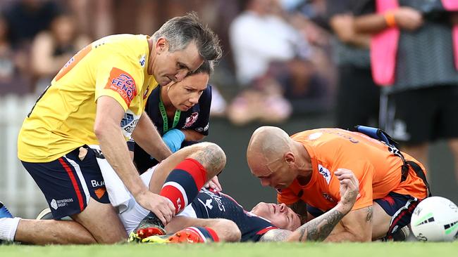 Jake Friend is attended to by Roosters trainers after a head knock at the SCG.