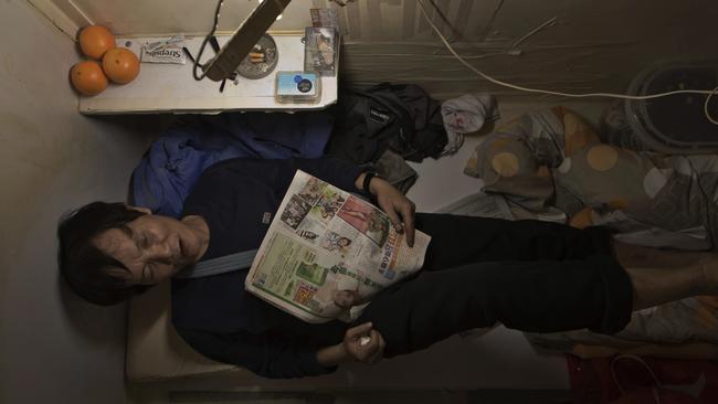 A resident known only by his surname Yeung is seen resting in their home, surrounded by his belongings. Picture: Kin Cheung/AP