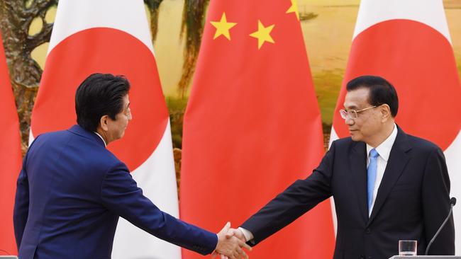 Japan's Prime Minister Shinzo Abe (L) shakes hands with Chinese Premier Li Keqiang. Picture: AFP