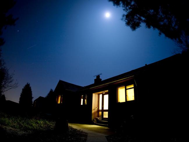 A wooden house lit by the moon. istock image