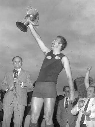 LVFL president Jack Huxtable, left, and secretary Joe Hutchison after the 1981 grand final that Bairnsdale won. Redlegs coach Trevor Fletcher holds aloft the premiership cup. Picture: Supplied