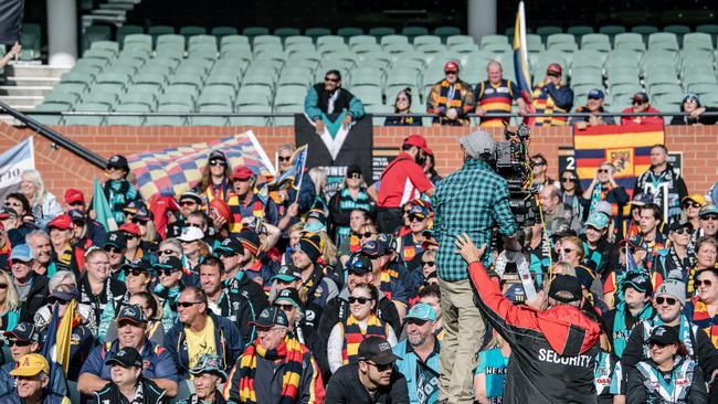 Crows and Port Adelaide fans sitting together on the southern side of Adelaide Oval early this morning to be extras in the film 