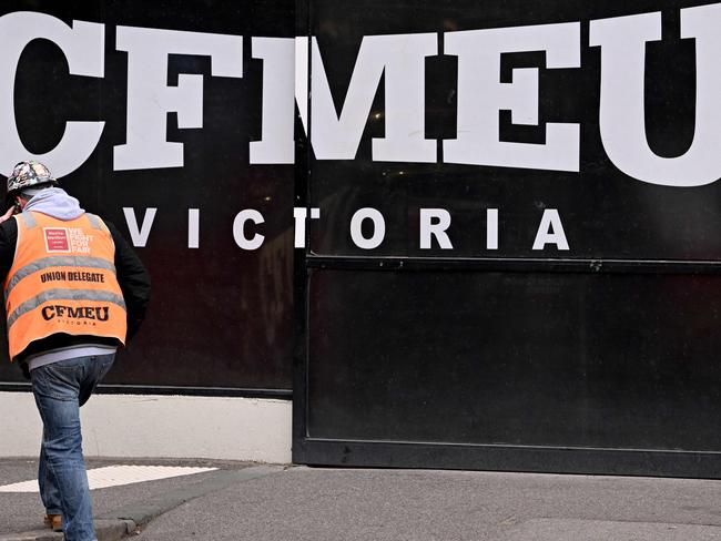 A union official walks past the Victorian headquarters of the Construction, Forestry and Maritime Employees Union (CFMEU) in Melbourne on July 17, 2024. Australia on July 17 pledged to clean up one of its most powerful trade unions, which has been tarred by accusations of intimidating "thuggery", corruption and cosy ties to organised crime. (Photo by William WEST / AFP)